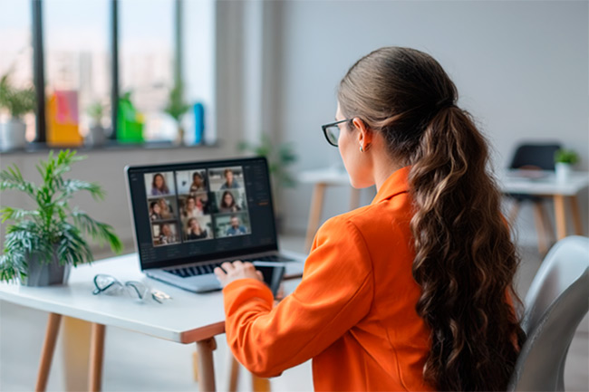 Mujer conectada a una reunión virtual a través de su computador personal